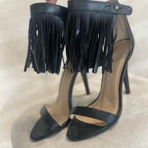 Black heels with leather fringe wrapped around the ankle